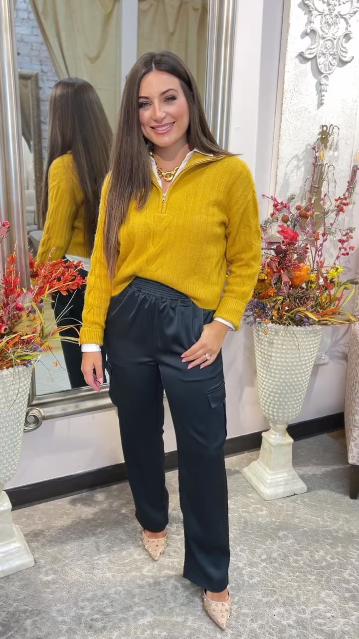 wearing a yellow blouse and black pants
